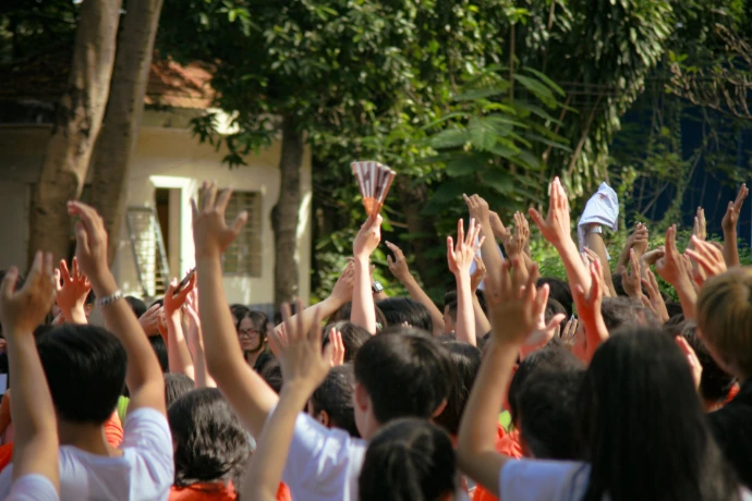 a group of people holding up their hands in the air